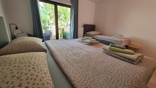 three beds in a room with a window at Brne Family House in Postojna