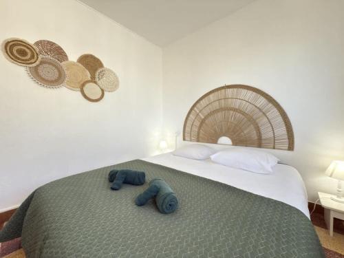 - une chambre avec un lit et 2 chaussons bleus dans l'établissement Valras-Loc - Appartement en Front de Mer avec Balc, à Valras-Plage