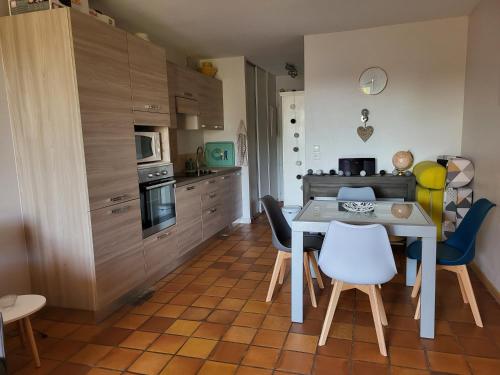 une cuisine avec une table et des chaises dans une pièce dans l'établissement Studio, à Saint-Raphaël