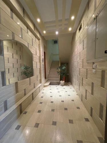 an empty hallway with a stone wall and stairs at Luxe Nest Guest House Apartment 102 in Luxor
