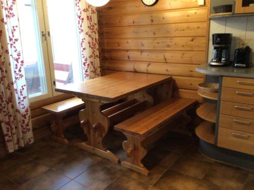a kitchen with a wooden table and bench in a room at Koli country club basic in Hattusaari