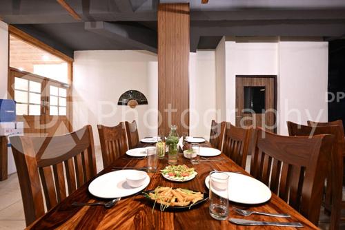 a wooden table with plates of food on it at The Ravasa in Manāli