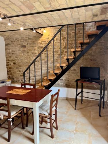 a dining room with a table and a staircase at agriturismo borgo del ginepro in Castiglione Messer Raimondo
