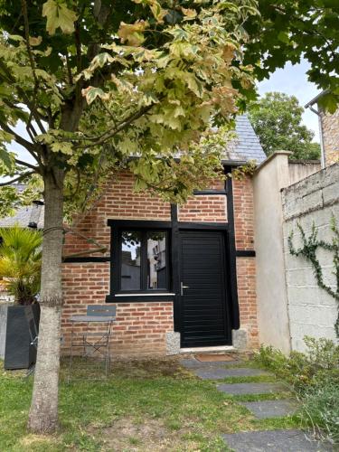 una casa in mattoni con una porta nera e una finestra di La petite maison du Thabor a Rennes