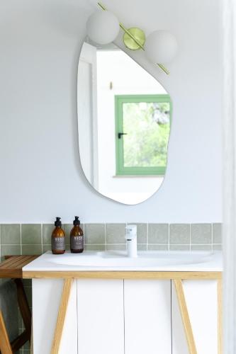 a bathroom with a mirror and a white sink at Spot Local in Moncarapacho