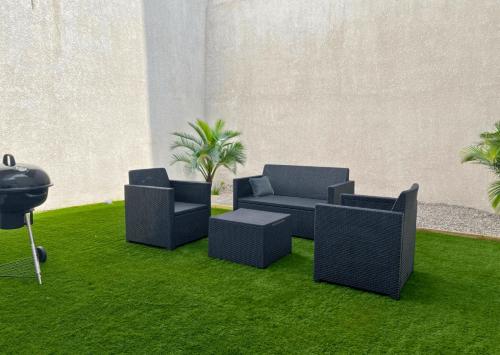 deux chaises et un canapé sur l'herbe dans l'établissement La Casa Hacienda, Hypercentre, Idéal Groupe, Terrasse, à Saint-Omer