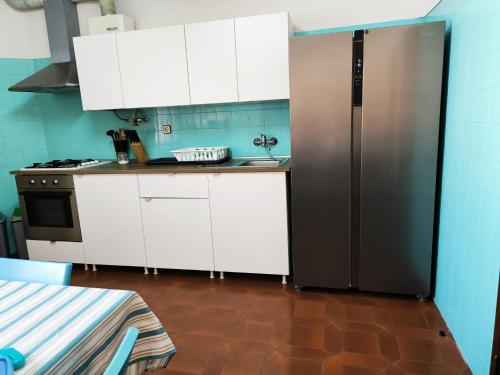 a kitchen with white cabinets and a stainless steel refrigerator at Beach House Surfing Baleal Peniche in Baleal
