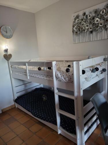 une étagère dans une pièce avec une horloge sur un mur dans l'établissement Studio, à Saint-Raphaël