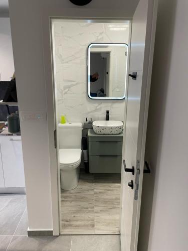 a bathroom with a sink and a toilet and a mirror at VALI in Baška