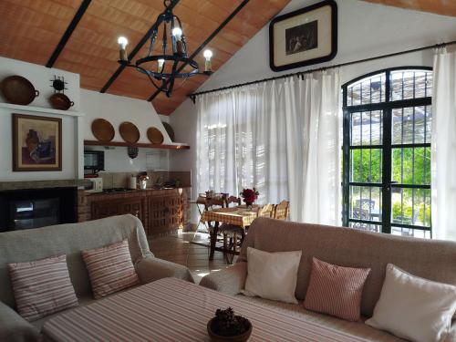 a living room with two couches and a dining room at Casa Rural del Guadalora in Hornachuelos