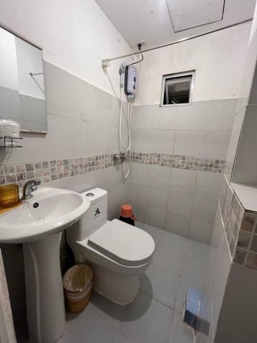 a bathroom with a toilet and a sink at Casa Montemar Heights in Coron