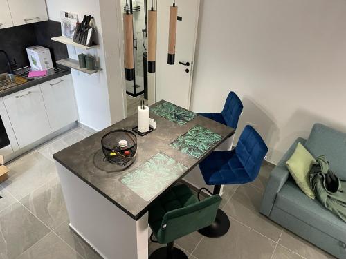 a kitchen with a table and two blue chairs at VALI in Baška