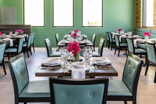 a dining room with tables and chairs and pink flowers at Ocean Breeze Resort in NCA