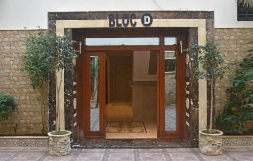 an open door of a building with two potted plants at Ibtissam luxury residence in Larache