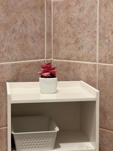 a white shelf with a flower in a bowl on it at Al Tribunale Guest House in Palermo