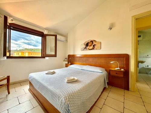 un dormitorio con una cama y una ventana en Sea Whisper - Joy Collection, en Santa Maria Navarrese