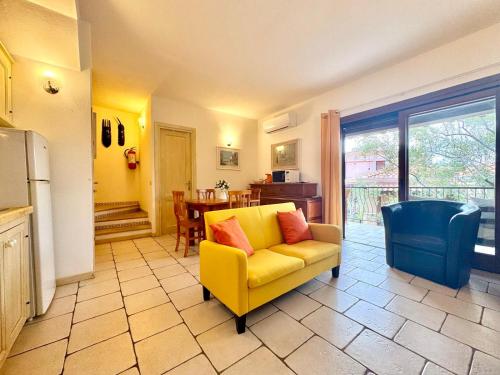 Una sala de estar con un sofá amarillo y una mesa. en Sea Whisper - Joy Collection, en Santa Maria Navarrese
