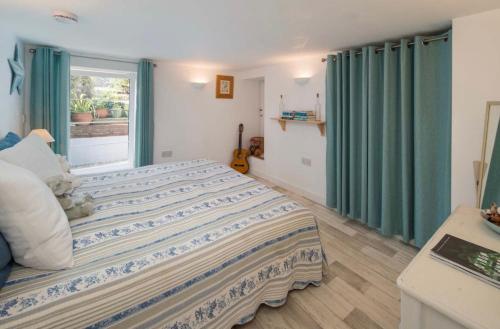 a bedroom with a bed with green curtains and a window at Serendipity flat in Isle of Wight