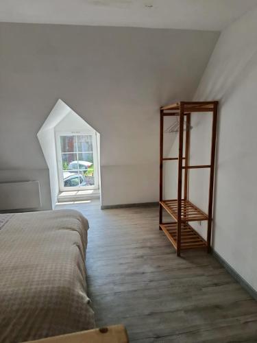 une chambre avec un lit et une étagère à côté d'une fenêtre dans l'établissement Petite maison à la campagne, à Faverolles