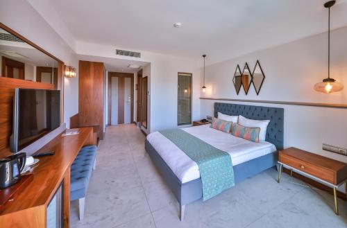 a hotel room with a bed and a flat screen tv at Molino Hotel in Kas
