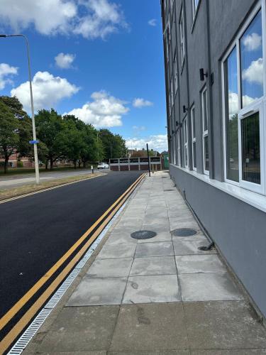 an empty sidewalk next to a building on a street at Train Station Aparthotel - Free Wifi, Free Parking in Scunthorpe