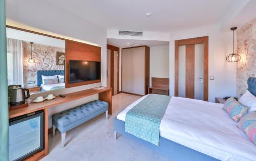 a bedroom with a large bed and a tv at Molino Hotel in Kas