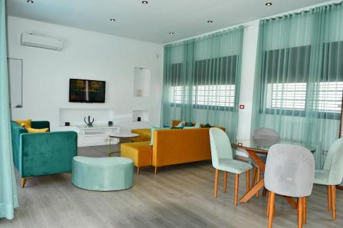 a living room with a couch and a table and chairs at Chacha house in Yasmine