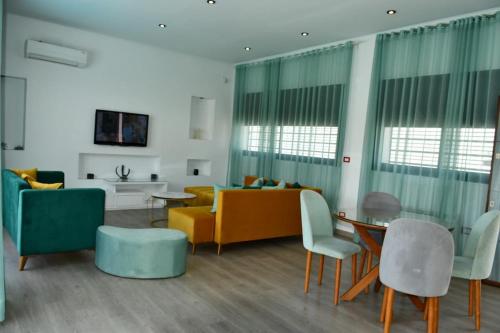a living room with a couch and a table and chairs at Chacha house in Yasmine