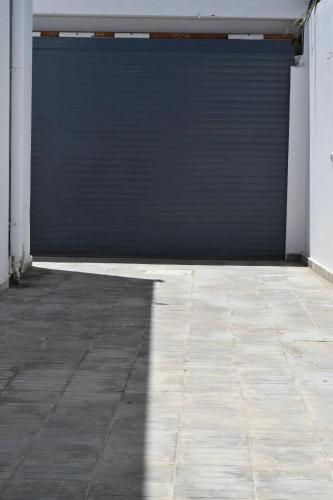 a garage door with a shadow on a tile floor at Chacha house in Yasmine