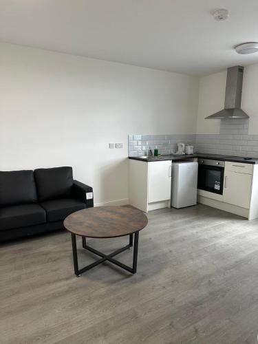 a living room with a couch and a coffee table at Train Station Aparthotel - Free Wifi, Free Parking in Scunthorpe