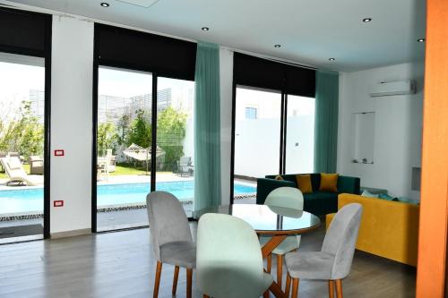 a living room with a table and chairs and a couch at Chacha house in Yasmine