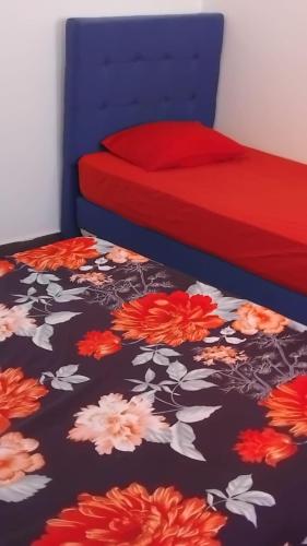 a bedroom with two beds with red and orange flowers at Chacha house in Yasmine