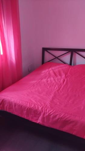 a bedroom with a bed with a pink blanket at Chacha house in Yasmine