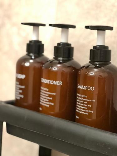 three bottles of detergent sitting on a metal shelf at Luxury Spa with Sauna, Bath and Cinema Private in Bodegraven