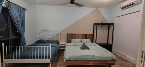 a bedroom with two beds and a crib at Sunway Geo Suites AG0E at Sunway City by Ezprop in Subang Jaya