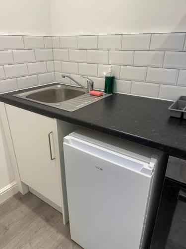 a kitchen counter with a sink and a dishwasher at Train Station Aparthotel - Free Wifi, Free Parking in Scunthorpe