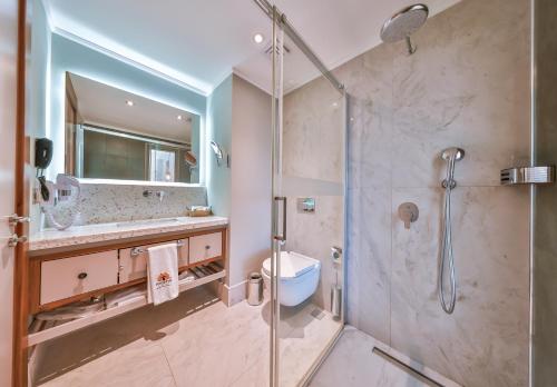 a bathroom with a shower and a toilet and a sink at Molino Hotel in Kas