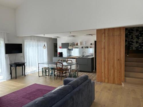 un salon avec un canapé et une table dans l'établissement Maison à belle terrasse à Mérignac, à Mérignac