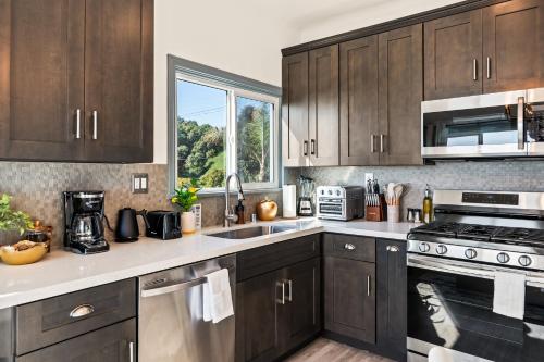 a kitchen with wooden cabinets and a stove top oven at Newly Remodeled Cozy Beach Retreat Ocean Views in Manhattan Beach