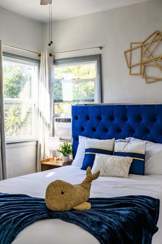 a stuffed teddy bear sitting on top of a bed at Newly Remodeled Cozy Beach Retreat Ocean Views in Manhattan Beach