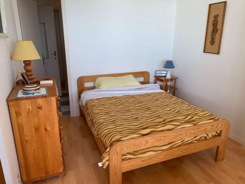 Ce petit lit se trouve dans un dortoir doté d'une table de chevet et d'une sidx. dans l'établissement Le panorama plein sud Saint Hilaire de Riez, à Saint-Hilaire-de-Riez