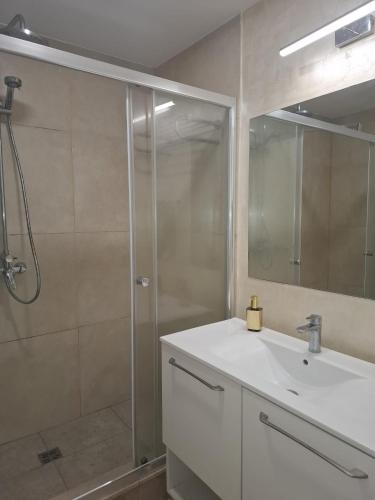 a bathroom with a white sink and a shower at My Blaxy apartment in Olimp