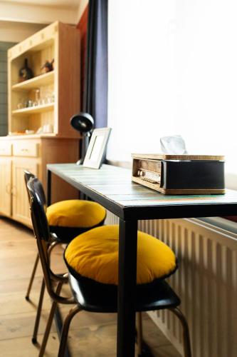 a table with two chairs and a laptop on it at Stijl en kleur in Diest