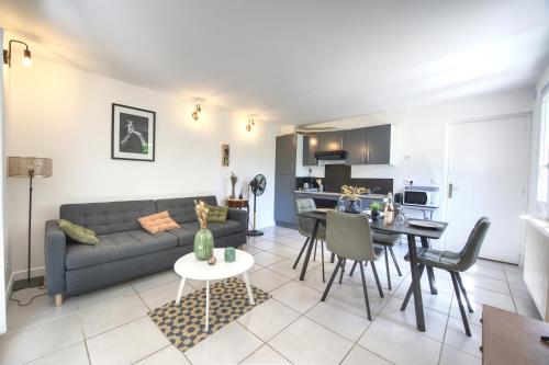 un salon et une cuisine avec un canapé et une table dans l'établissement Le Cocon - Terrasse & BBQ - Centre historique Gare et Arènes à Proximité - Emplacement Idéal, à Arles