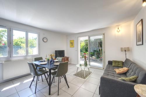 un salon avec un canapé et une table dans l'établissement Le Cocon - Terrasse & BBQ - Centre historique Gare et Arènes à Proximité - Emplacement Idéal, à Arles