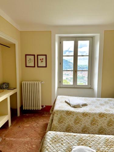 a bedroom with two beds and a window at Villa Adelaide Lakeview in Como