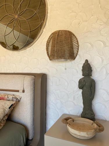 a table with a statue on it next to a bed at Portugals Infinity Eco Suite Resort in Tavira