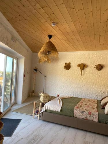 a bedroom with a bed and a wooden ceiling at Portugals Infinity Eco Suite Resort in Tavira