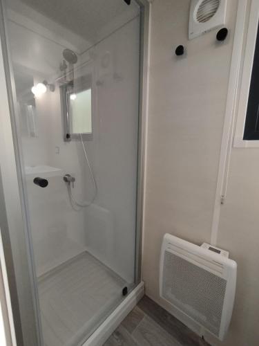 une douche avec une porte vitrée dans une salle de bain dans l'établissement Tiny house bord de rivière, à Beaumont