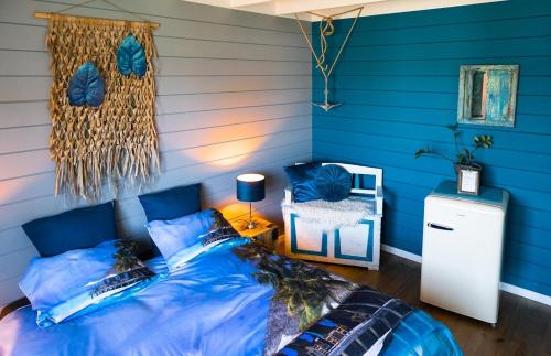 a blue room with a bed and a chair at Stijl en kleur in Diest